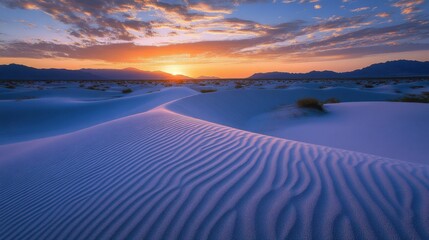 A vast desert landscape with sand dunes stretching into the horizon at sunrise.