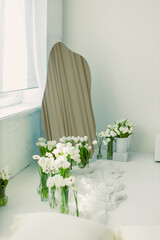 This elegantly designed minimalist room features a stunning curved mirror that enhances the space, complemented by fresh white flowers adding a touch of natural freshness to the decor