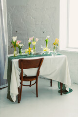 Immerse in a delightful Floral Table Setting for Spring Gatherings, featuring vibrant Fresh Blooms and a Vintage Wooden Chair, adding charm and comfort to elevate your celebration