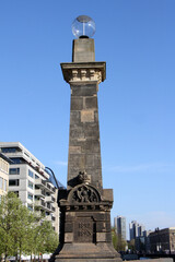 Obraz premium Historic Obelisk Monument on Friedrichsbrücke in Berlin with Modern Buildings in Background