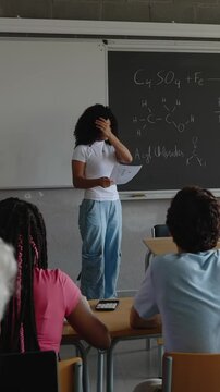 Vertical HD video of young high school multiracial student girl giving a presentation in front of his classmates. Education and back to school concept.