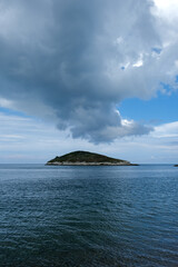 Storm clouds over small sea island