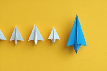Creative Business Concept with White and Blue Paper Airplanes on Yellow Background for Innovation and Leadership