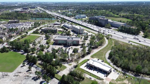 Business park, industrial and residential zones along lush green Cypress Creek, Texas State Highway 249 Tomball Parkway, downtown Houston skylines in background, office buildings, hotels, flyover