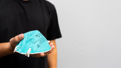 Man Holding N95 Mask for PM2.5 Protection Against Air Pollution