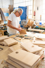 A passionate craftsman skillfully shaping beautiful wood in a bright workshop filled with tools and materials