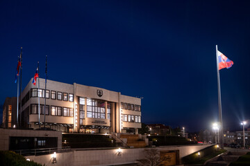 Slovak National Council building in Bratislava, Slovakia, illuminated at night with Slovak flags in...