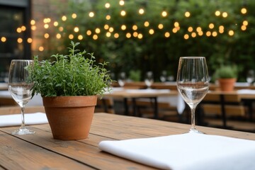 Cozy outdoor dining setting featuring potted herbs, elegant glas