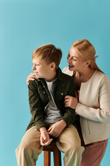 Mother and son share a joyful moment on a blue background with warmth and love