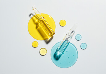 Ampoules with yellow and blue liquid drops display on white background showcase ampoule colors and liquid forms