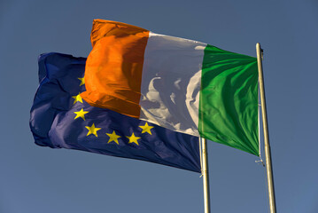 Irish flag in front of the European flag.