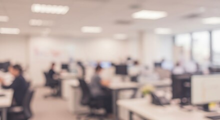 Blurred office interior with people working at desks and computers in a bright and modern space