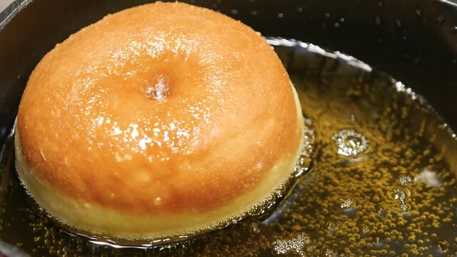 食用油で揚げている穴の空いたドーナツの動画。
