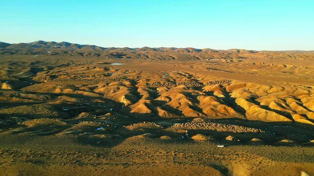 view of hilly valley with giant round and oval stones in the distance low mountains in the foreground eded off-road white car kazakhstan mangystau