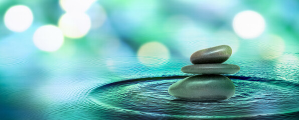 three meditation stones in rippled water surface isolated on blurred background banner with...