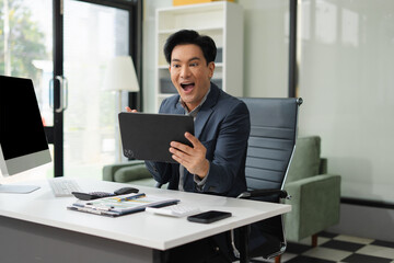 Excited man work distant on Tablet talk on cellphone celebrate online win. Happy young male use...