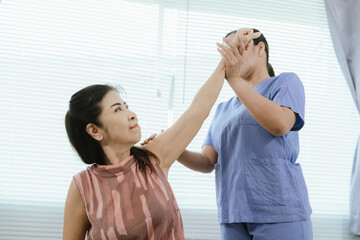 Fototapeta premium Elderly patients receive physical therapy. A caring doctor or physical therapist will assist with rehabilitation exercises to improve balance, relieve pain, and enhance overall health.