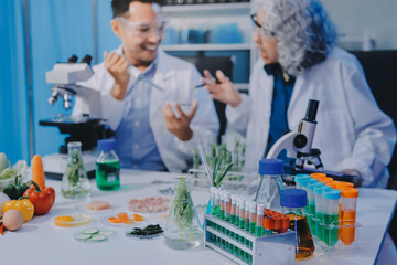 Fototapeta premium Team Asian scientists in a lab conducting food research using a microscope and lab equipment, showcasing innovation in food science and biotechnology