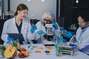 Team Asian scientists in a lab conducting food research using a microscope and lab equipment,...