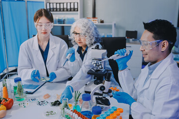 Team Asian scientists in a lab conducting food research using a microscope and lab equipment,...