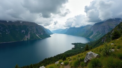 Cloudy Lovatnet lake in Norway during midday, captured from above with calm waters and lush green surroundings.