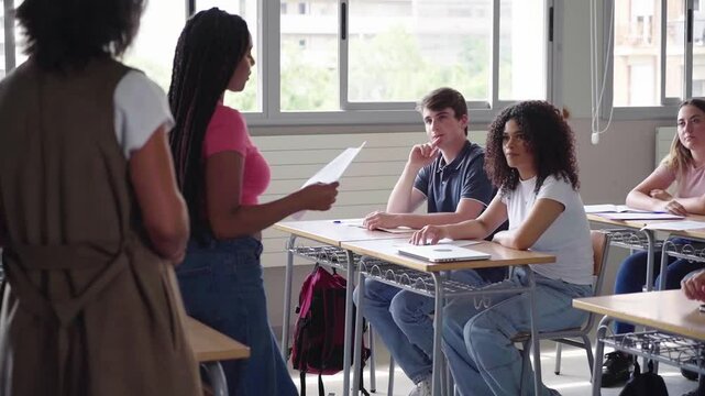 Large group of university students applauding classmate after presentation in classroom. Video with copy space.