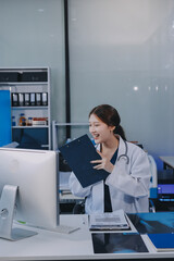 Medical health clinic beautiful Asian doctor working using smart tablet touching, stethoscope diagnosing patient analysis research examination healthcare provider service insurance in modern office