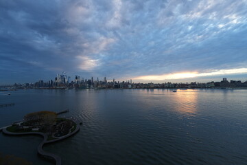 Morning Cloudy Sunrise with sunlight breaking through cloud over Midtown Manhattan New York City USA - view from Hoboken New Jersey