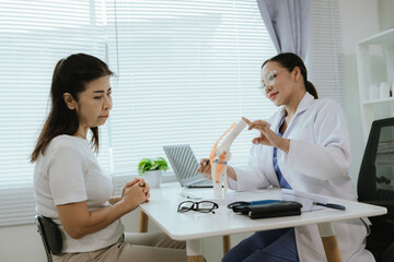 Female doctor who is explaining the treatment method of the knee joint to the woman patient