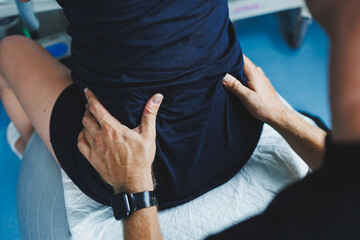 Pregnant woman feels severe pain during childbirth in hospital ward. Caring man helps woman during childbirth and massages her back. Support and love concept.