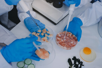 Team Asian scientists in a lab conducting food research using a microscope and lab equipment,...