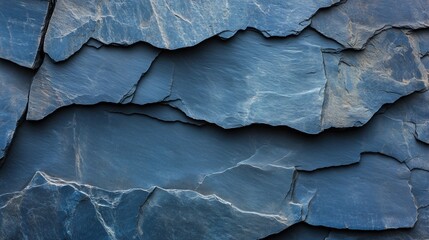 A textured background featuring dark blue slate rock with rough, uneven layers and deep cracks, perfect for abstract design projects