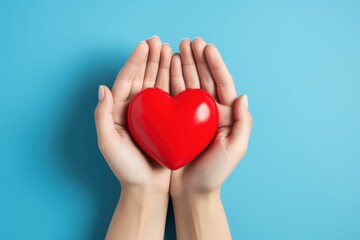 Obraz premium Tender Hands Holding Red Heart Symbol of Love Care Charity hope blue image giving health design 