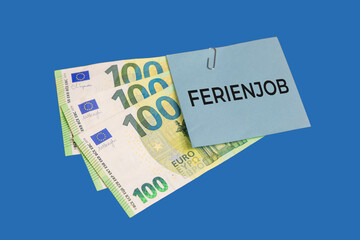 Ferienjob Symbolbild: Eurobanknoten und ein Zettel mit der Aufschrift FERIENJOB freigestellt vor...