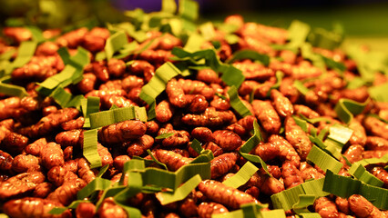Close-up of fried silkworm larvae, a Thai food sold at tourist attractions in Thailand.