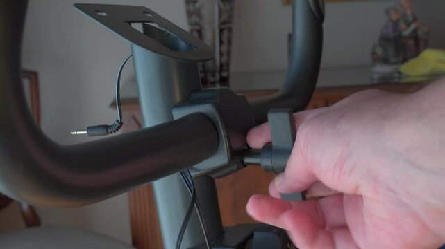 Man assembling and adjusting exercise bike handlebars