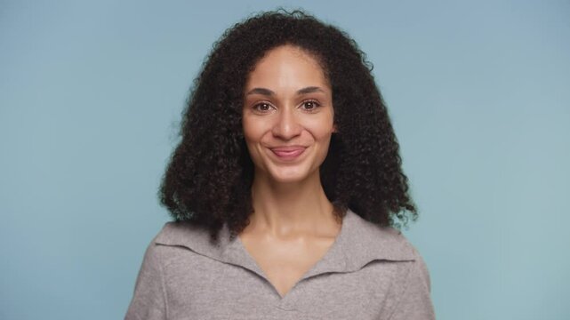 Playful Woman Smirking Against Blue Background