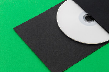 White CD, DVD, Blu Ray, Optical Disc printed side up in black envelope, on green background