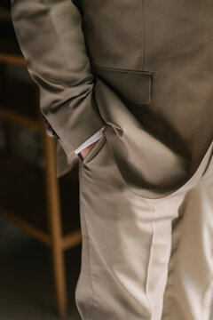 Hand in pocket of man's brown pants,Luxurious Brown Formula,A suited businessman adjusts his tie, a classic office fashion,