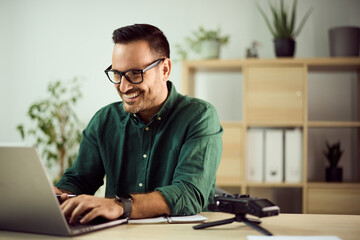 Smiling Professional Man Working on Laptop in Modern Office Environment