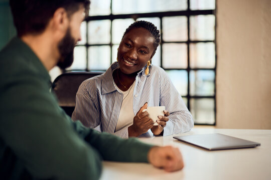 Friendly Office Discussion Between Colleagues in a Modern Workspace