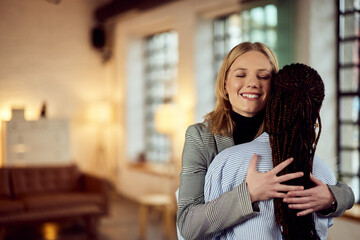 Business Colleagues Hugging in Warmly Lit Modern Office Interior