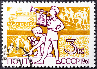 USSR - CIRCA 1961: A stamp printed in USSR . Boy with Clarion and girl, who planted plants without...