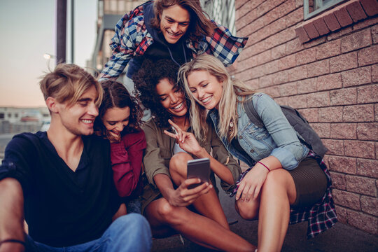 Gen Z friends taking fun selfie while exploring city streets