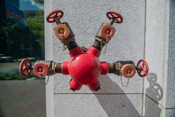 Red fire hydrant in granite wall of modern building.
