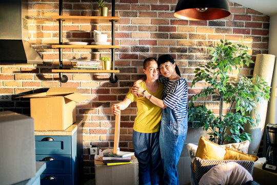 Lesbian couple embracing while moving into new home together