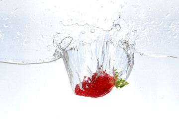 strawberries falling into water with splashes