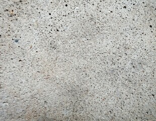 A rough, porous concrete texture in neutral gray, perfect for industrial or minimalist design backgrounds. Ideal for product photography or graphic overlays.