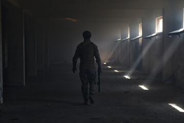 A professional soldier in an abandoned building shows courage and determination in a war campaign
