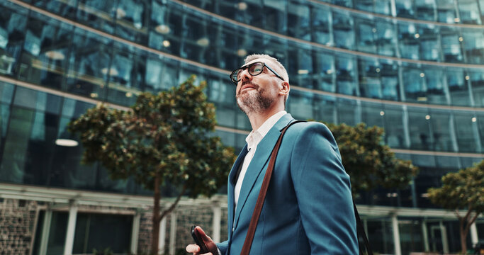 Travel, thinking or man in city with phone, appointment or ideas in urban town for opportunity. Mobile, financial advisor or mature consultant in low angle for corporate career, commute or decision